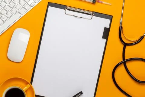 Top view of a doctor's table with notepad and pen stethoscope, keyboard, pres Stock Photos
