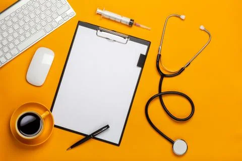 Top view of a doctor's table with notepad and pen stethoscope, keyboard, pres Stock Photos