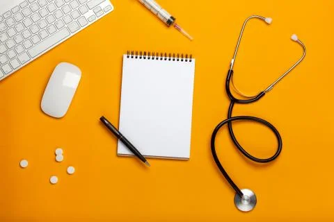 Top view of a doctor's table with notepad and pen stethoscope, keyboard, pres Stock Photos