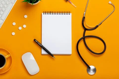Top view of a doctor's table with notepad and pen stethoscope, keyboard, pres Stock Photos