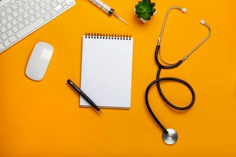 Top view of a doctor's table with notepad and pen stethoscope, keyboard, pres Stock Photos
