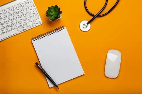 Top view of doctor's table with stethoscope keyboard notepad and pen Stock Photos