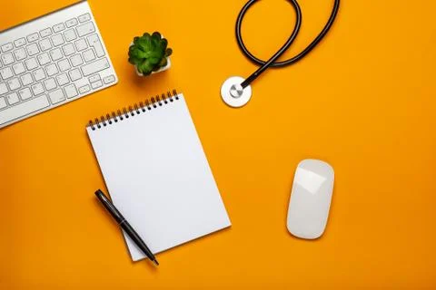 Top view of doctor's table with stethoscope keyboard notepad and pen Stock Photos