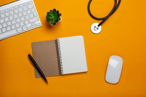 Top view of doctor's table with stethoscope keyboard notepad and pen Stock Photos
