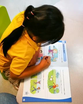 Top view of doing a workbook by a little girl. Stock Photos