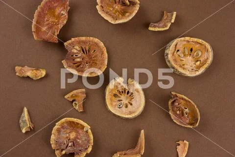 Top view dried bael fruit (matum) slices on a brown background ~ Hi Res ...