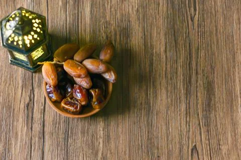 Top view of dried dates served on a wooden bowl and a Arabic lantern Stock Photos