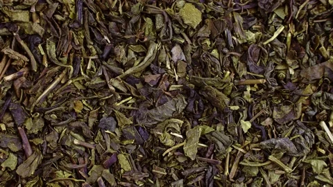 Top view of dried green tea leaves texture rotation close up Stock Footage 235661000