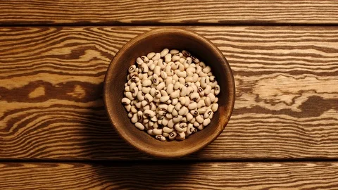 TOP VIEW: Dried white beans fill a wooden dish (stop motion) Stock Footage 97423491