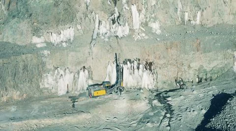 Top view of a drilling machine working in the open-pit mine Photos