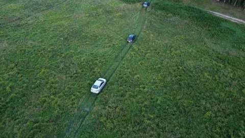Top view on the driving car of the mountain road through the green field. Drone Stock Footage 159097874
