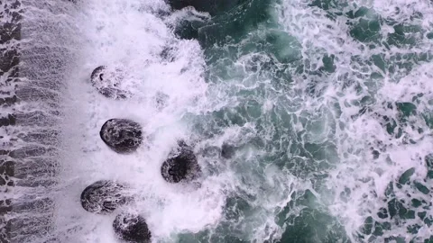 Тop view from drone above of foamy sea waves crashing into a pier with splash Stock Footage 197510819
