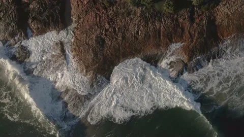 Top view drone aerial of waves crashing at rocky coastline with boardwalk Video stock 164764978