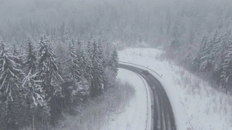 Top view from a drone of a car driving on a snowy Video stock 236773254