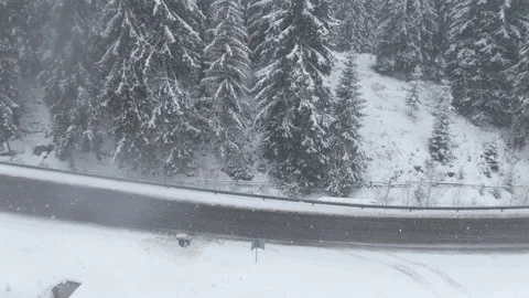 Top view from a drone of a car driving on a snowy Stock Footage 236773757