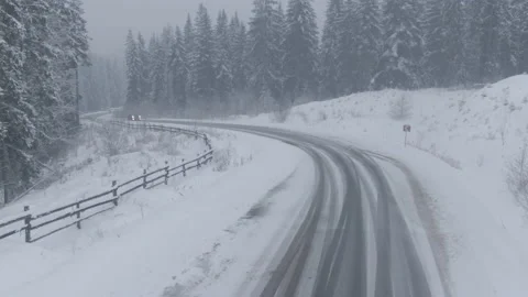 Top view from a drone of a car driving on a snowy Stock Footage 236774127