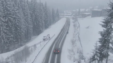 Top view from a drone of a car driving on a snowy Stock Footage 236774164