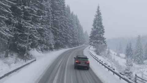 Top view from a drone of a car driving on a snowy Stock Footage 236774328