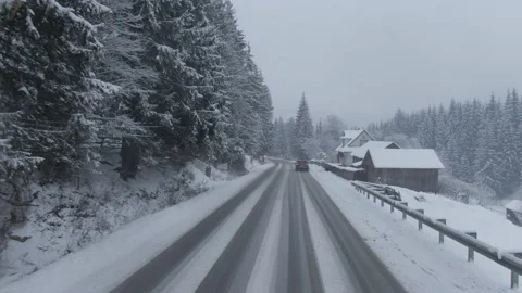 Top view from a drone of a car driving on a snowy Stock Footage 236774377