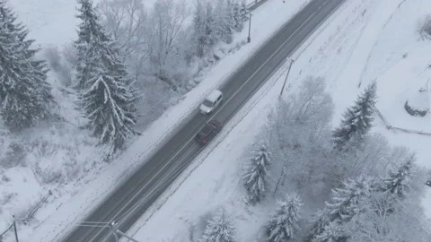 Top view from a drone of a car driving on a snowy Stock Footage 236774702