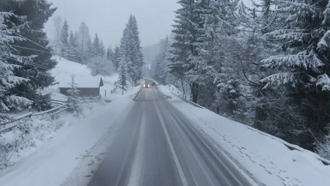 Top view from a drone of a car driving on a snowy Stock Footage 236775060