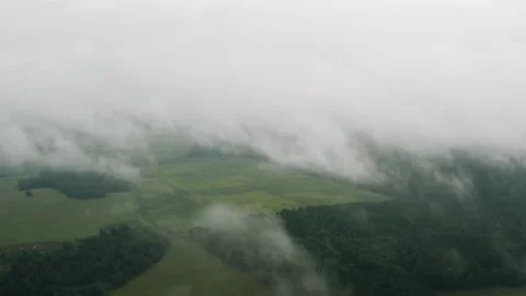Top view drone flies in rain clouds rolling over forest. Cloudy, misty weather Stock Footage 138634259