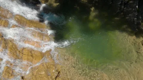 Top view from Drone flying over the waterfall surrounded by rocks and river Stock Footage 126828697