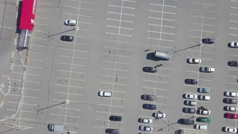 Top view from a drone landing to the ground with a twist in a car park with cars Stock Footage 220045480
