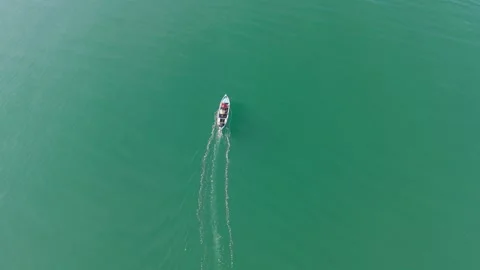 Top view drone shot of small boat on green water Video stock 331119869