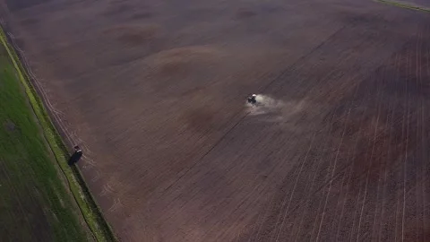 Top view from a drone of a tractor plowing and sowing ground in countryside Stock Footage 241019939