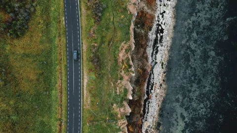 Top view, drone zooms in tracking black SUV car driving on autumn road trip near Stock Footage 105603923
