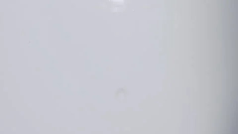 Top view of drop falls into water and diverging circles of water on white Video stock 136026430