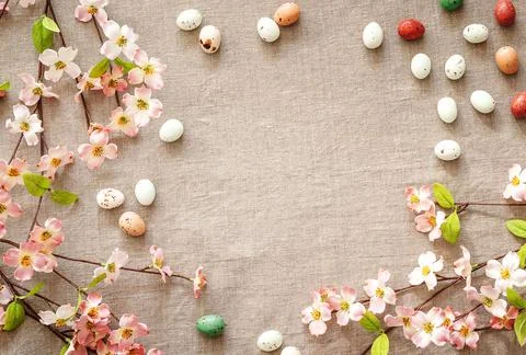 Top view of Easter eggs and flowers on a beige background. Stock Photos