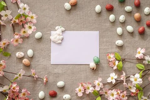Top view of Easter eggs and flowers on a beige background. Stock Photos