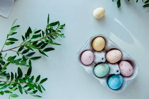 Top view Easter holiday concept. Pastel colors painted eggs in a cardboard box Stock Photos