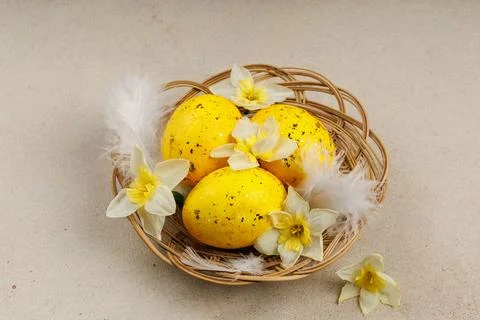 Top view of Easter nest with yellow eggs, feathers and daffodils Foto stock