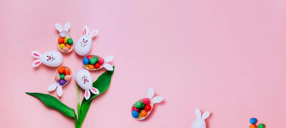 Top view Easter pink background with flower shape made of funny eggs containers Foto stock