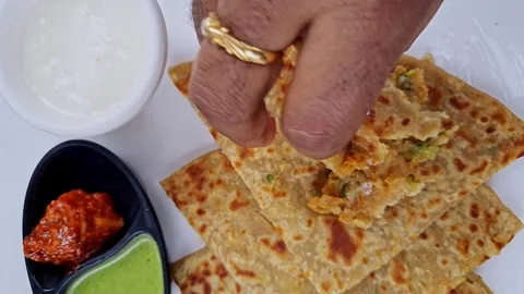 Top view of eating popular Indian food aloo paratha or potato stuffed flat .. Stock Footage 265231853