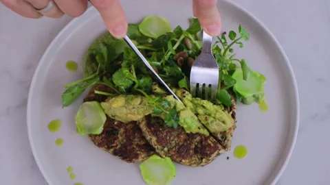 Top view of eating vegan vegetable pancakes with squash, fresh avocado and Stock Footage 169514747