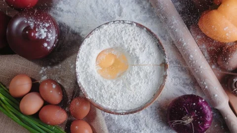 Top view of an egg falling into a bowl of flour. Slow motion 4K video Stock Footage 148766088