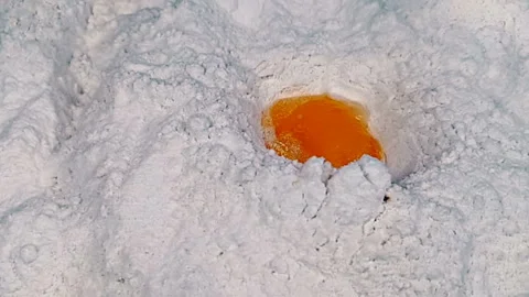 Top view of an egg falling into flour Vidéo 252136005