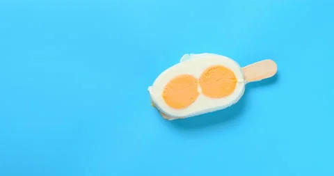 Top view egg shape popsicle melting timelapse on blue background at 8k Stock Footage 135199012