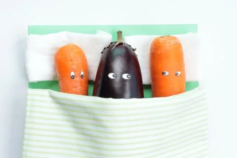 Top view of eggplant lying with two carrots in bed Foto stock