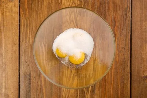 Top view of eggs and sugar in a bowl Stock Photos