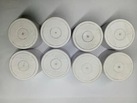 Top View of Eight White Plastic Bottle Caps Arranged in Two Rows Stock Photos