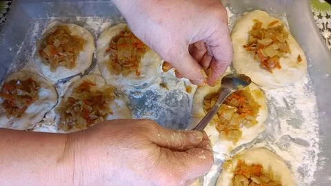 Top view of elderly female hands on the left in flour leveling fried Stock Photos