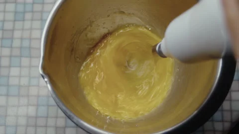 Top view, elderly woman's hand beating eggs with kitchen mixer in metal bowl Stock Footage 337121928