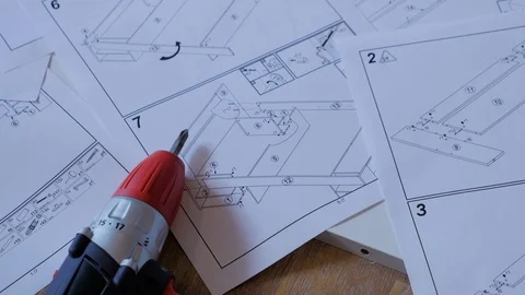 Top view of electric screwdriver and furniture assembly instructions. Stock Footage 108727110