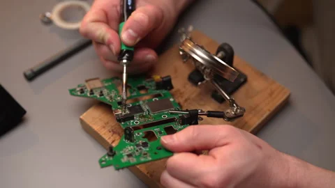 Top view of electronic technician using soldering iron to repair circuit board Stock Footage 304857478