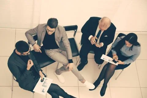 Top view. employees using their smartphones during a work meeting Stock Photos